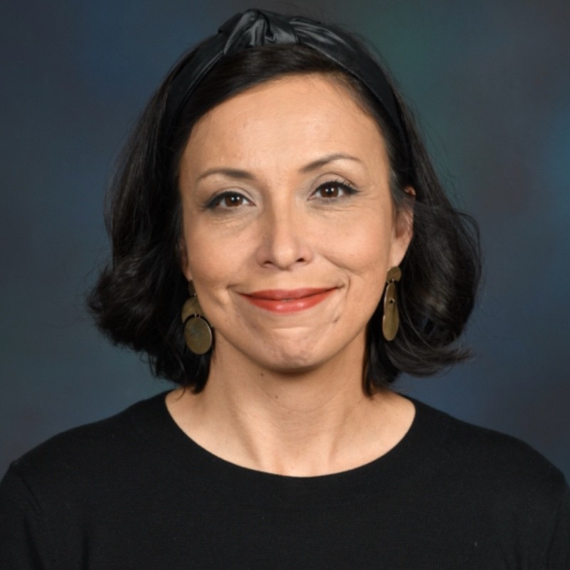 woman with shoulder length dark hair and a black shirt, she is grinning